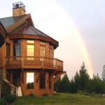 west elevation of house framed by a double rainbow